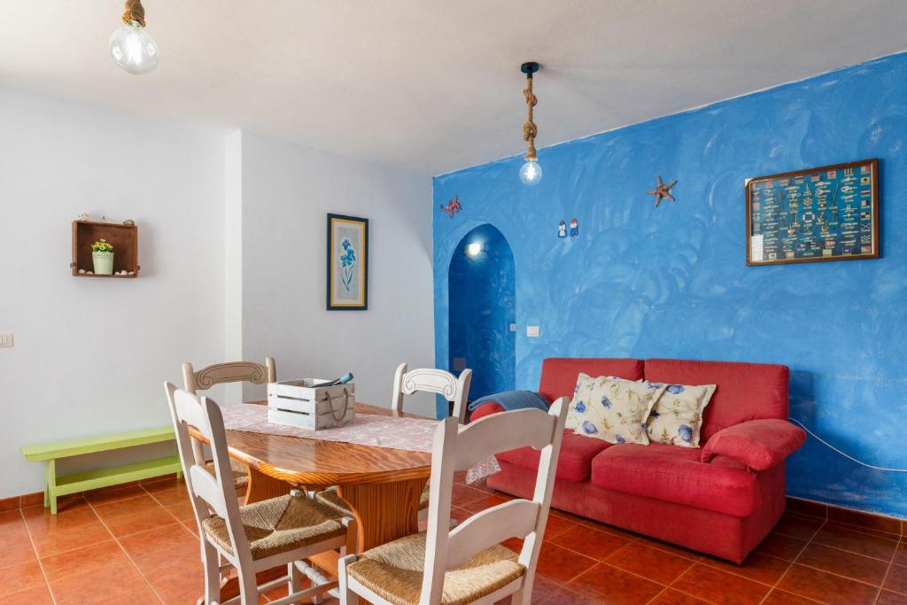 a living room with a table and a red couch at La Caletilla La Graciosa in Caleta de Sebo
