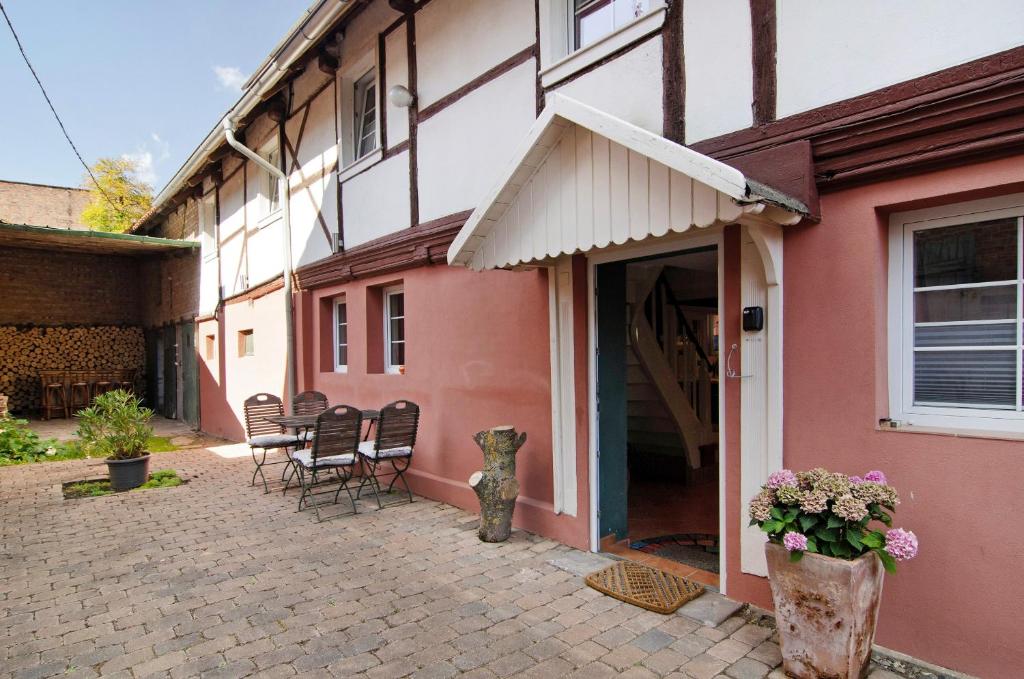 a pink house with chairs and a table in front of it at Art-Wohnung in Beierstedt