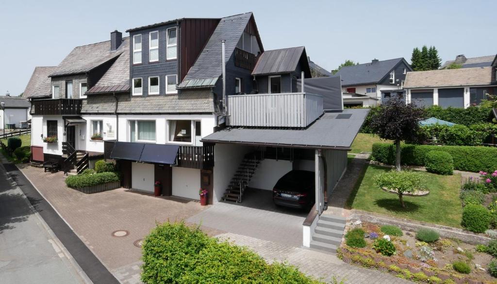 a house with a car parked in the driveway at Pension Haus Linden in Winterberg