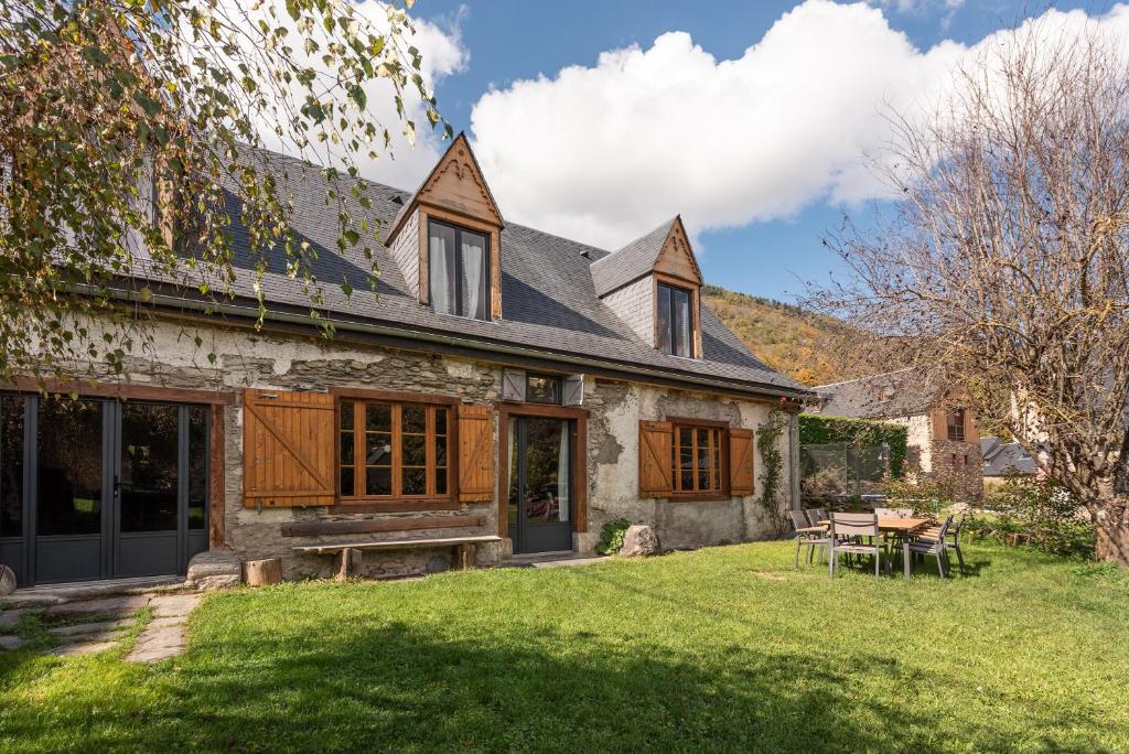 a stone house with a table in the yard at La Ketzerie à Adervielle in Adervielle
