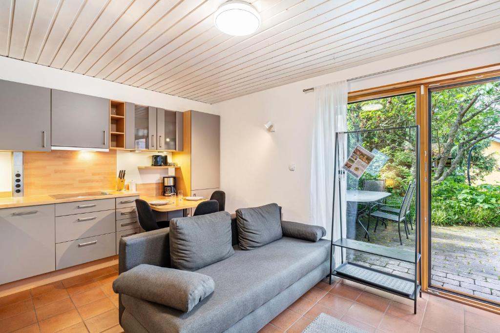 a living room with a couch and a kitchen at Haus Ersfeld – Gartenstudio in Bad Teinach-Zavelstein