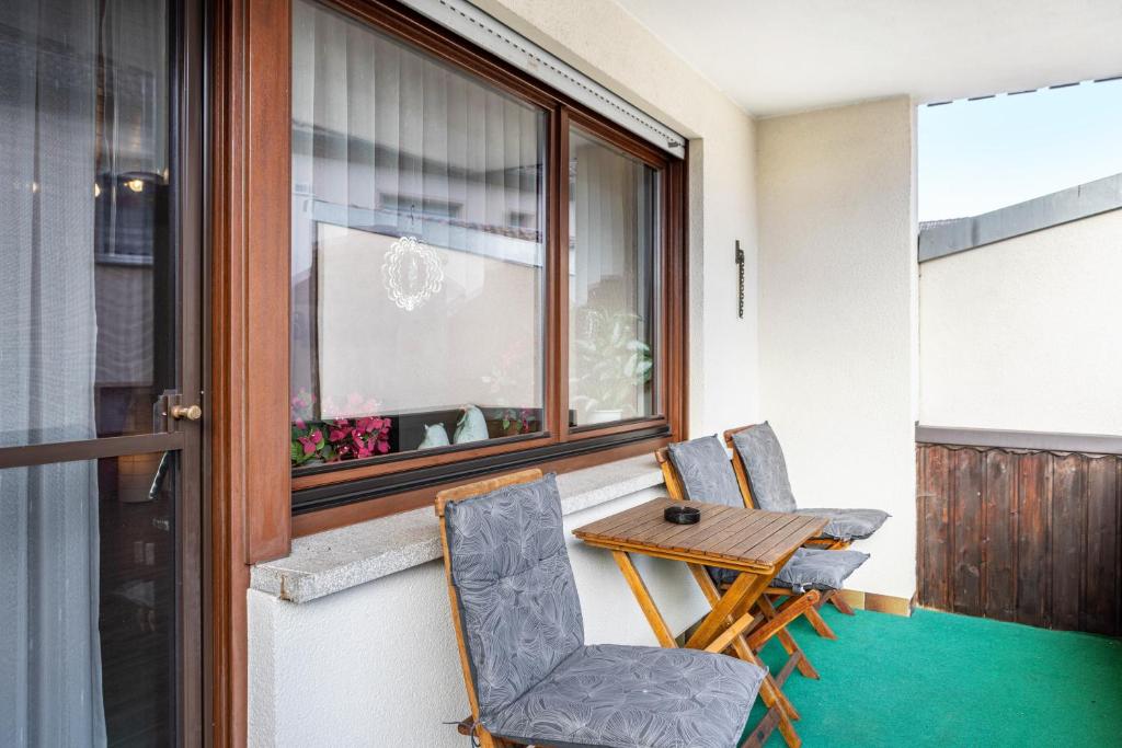 a balcony with a table and chairs and a window at Ferienwohnung Göpfert in Weyhers
