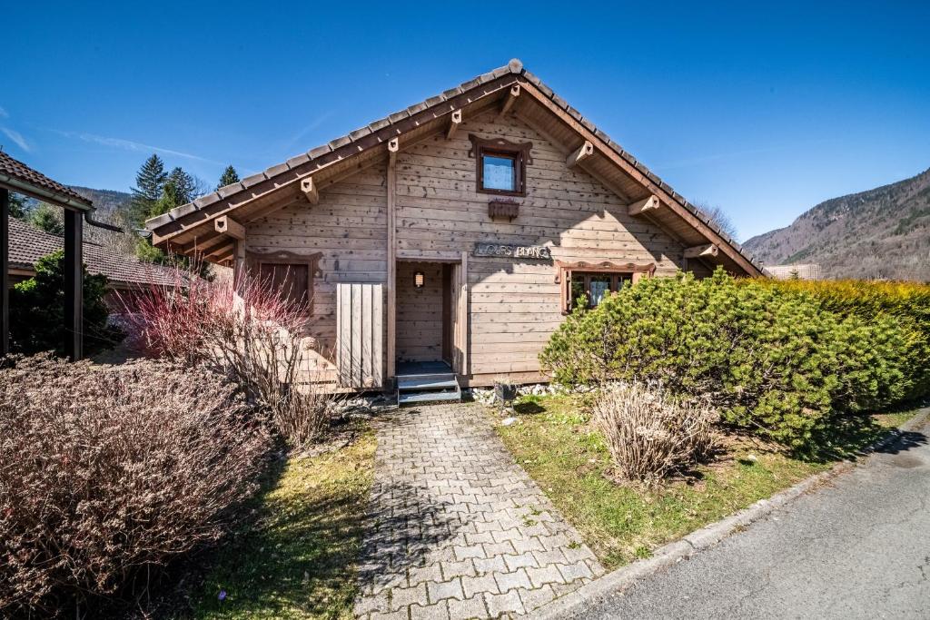 a small wooden building with a door in a yard at Chalet 6p Confort - L'ours blanc in Verchaix
