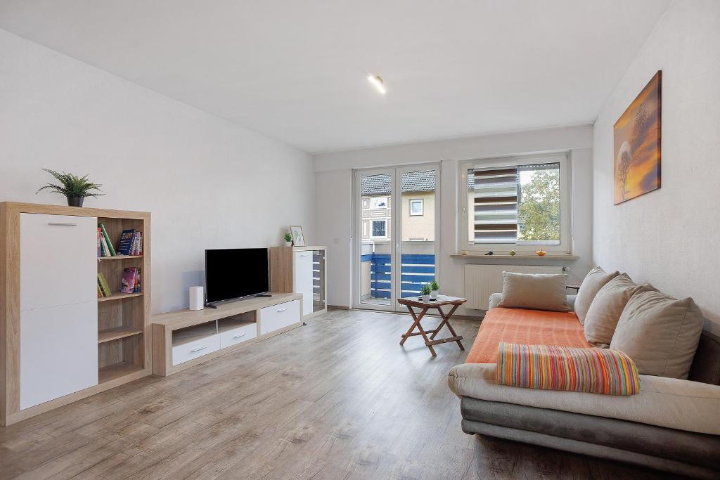 a living room with a couch and a tv at Allgäu Space in Marktoberdorf