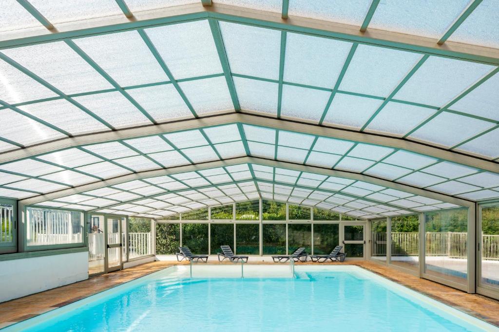 an indoor swimming pool with a glass roof at Petite maison Ortalon - Hasparren in Hasparren