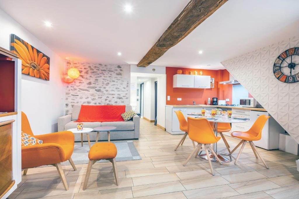 a kitchen and living room with orange chairs and a table at Les Glycines 1 in Les Épesses