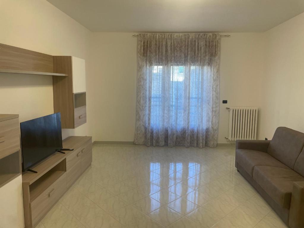 a living room with a couch and a television at Massimo Holiday house in Acquarica del Capo