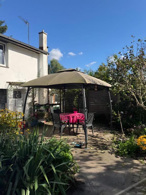 a table and chairs under an umbrella in a backyard at Monteurswohnung Rothentor4 in Dorf Mecklenburg