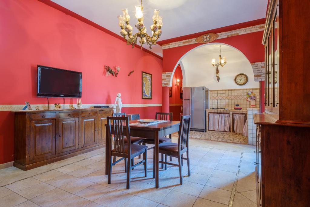 a dining room with red walls and a table and chairs at Villa Chanel in Monteroni di Lecce