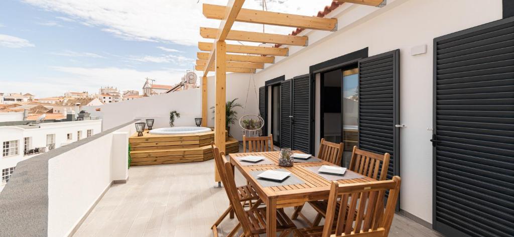 a balcony with a wooden table and chairs at Mi Casa Es Su Casa Nº5 in Albufeira