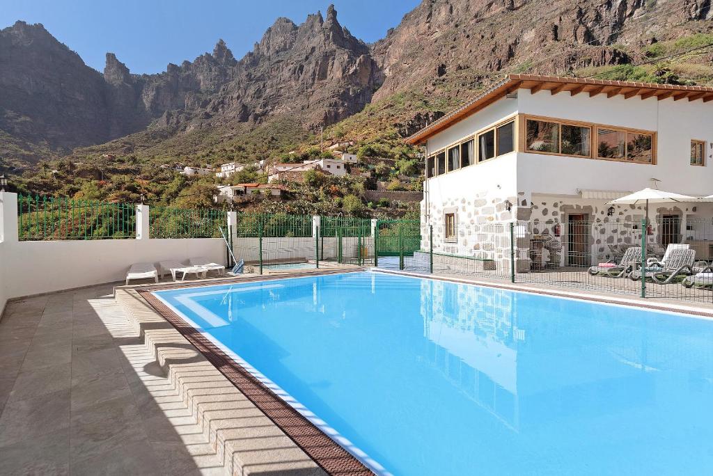a villa with a swimming pool in front of a mountain at Vivienda Vacacional Risco Blanco in San Bartolomé