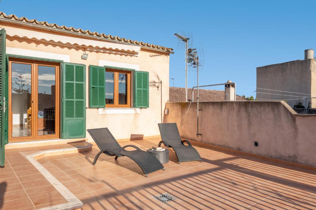 a patio with two chairs and a house at Caril in Binissalem