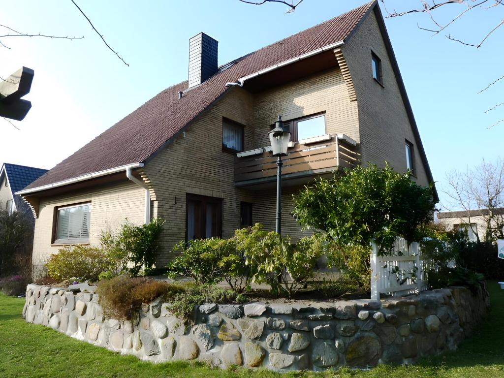 a house with a stone wall in front of it at Angelas Ferienwohnung in Cuxhaven