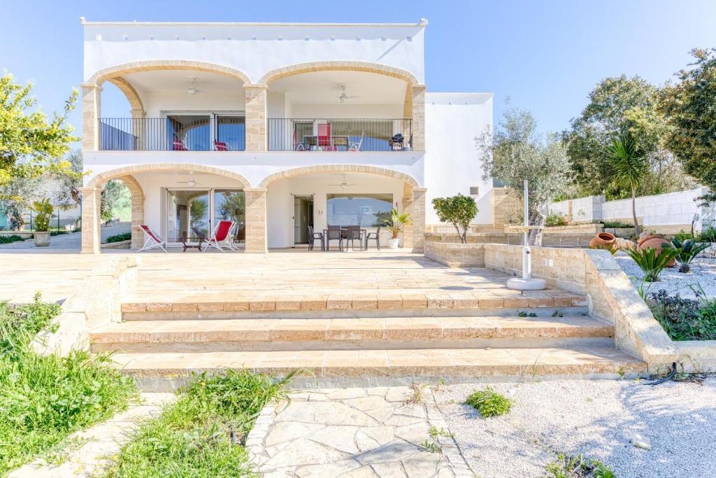 a large white house with stairs in front of it at Villa Bianca Appartament in Ugento