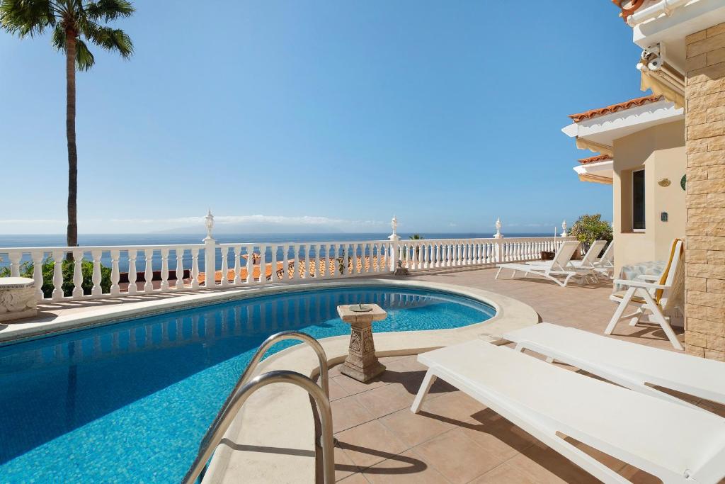 a villa with a swimming pool and a balcony at House Carla Private Pool Heated in Puerto de Santiago