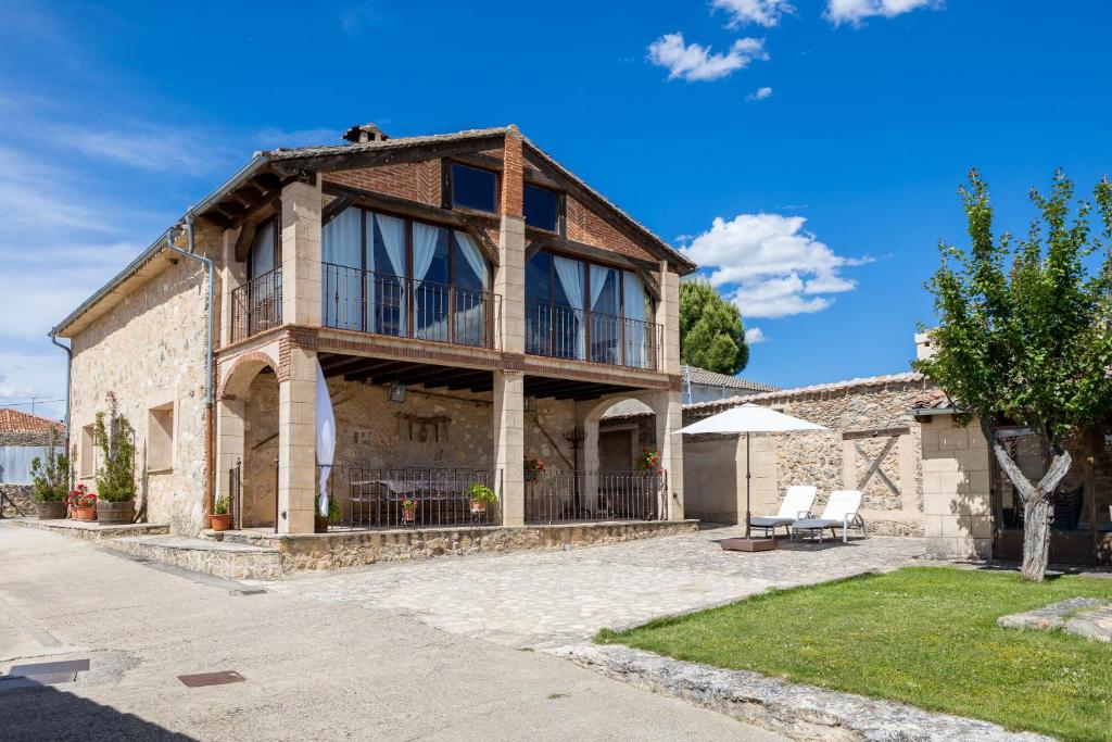 an old house with a balcony on a street at Casa el Arroyal in Rades de Abajo