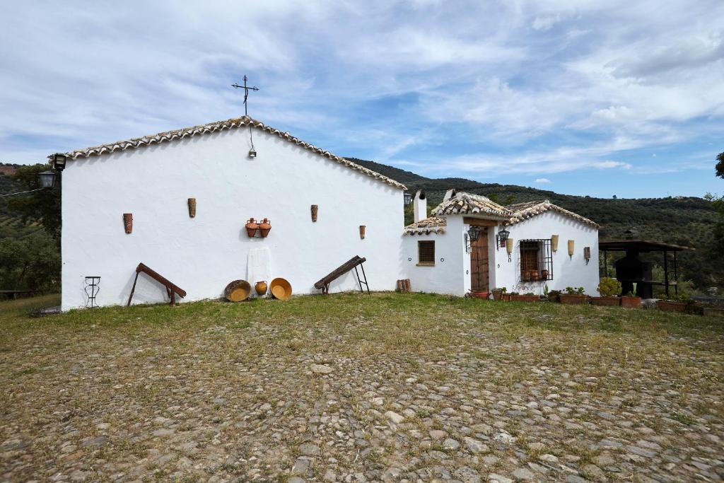 a white church with a cross on top of it at Cortijo Rural Majolero 3 in Castillo de Locubín