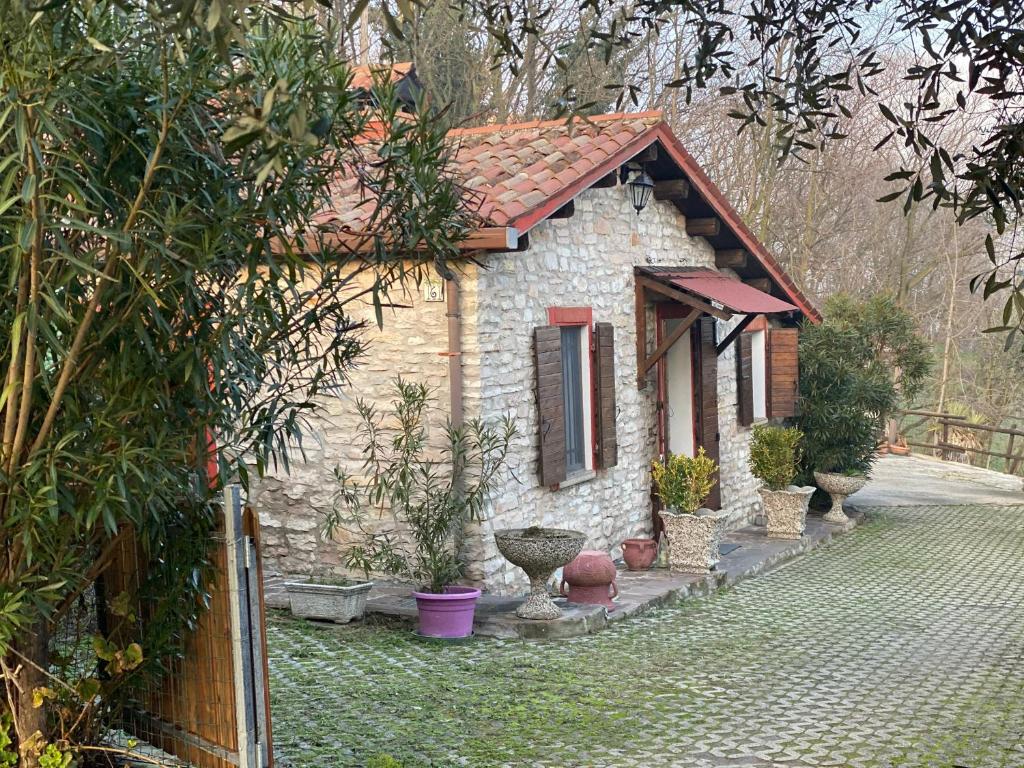 a small stone house with a fence in front of it at Casa dell'uliveto in Albettone
