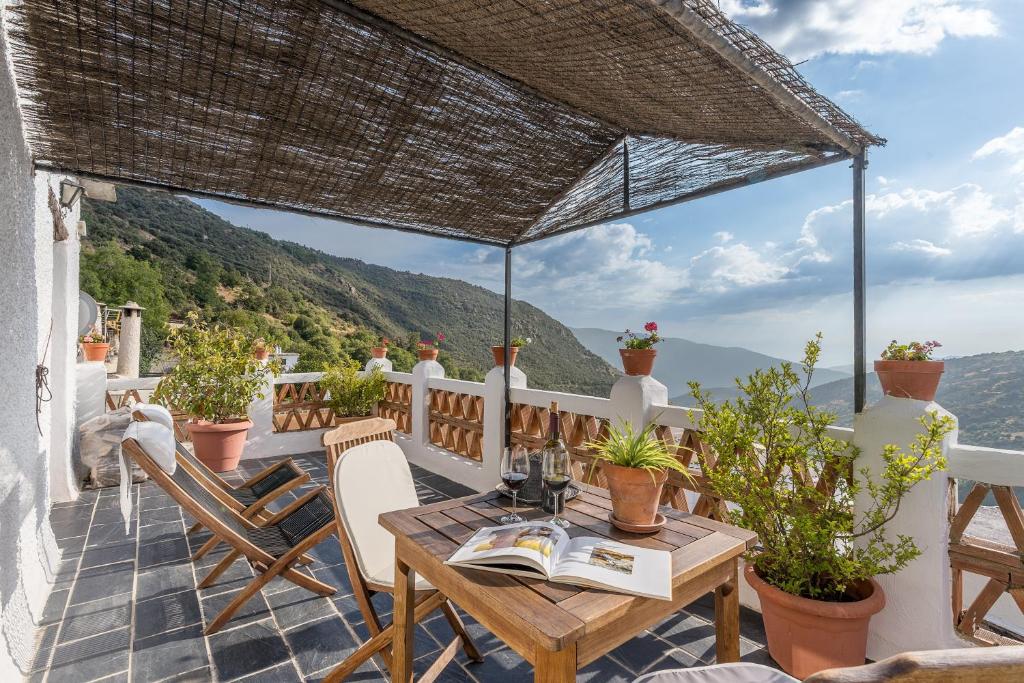 a table and chairs on a balcony with a view at Casa Belmonte in Bubión