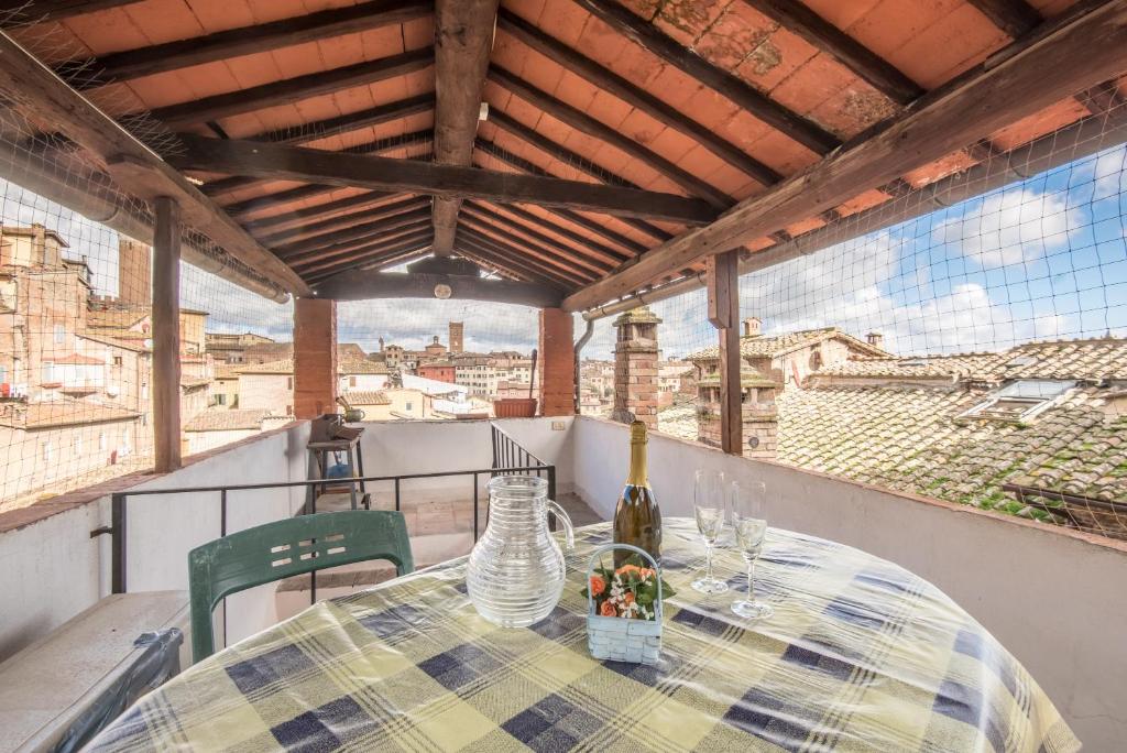 a table with a bottle of wine on a balcony at Il Campo Comfort apt with balcony in Siena