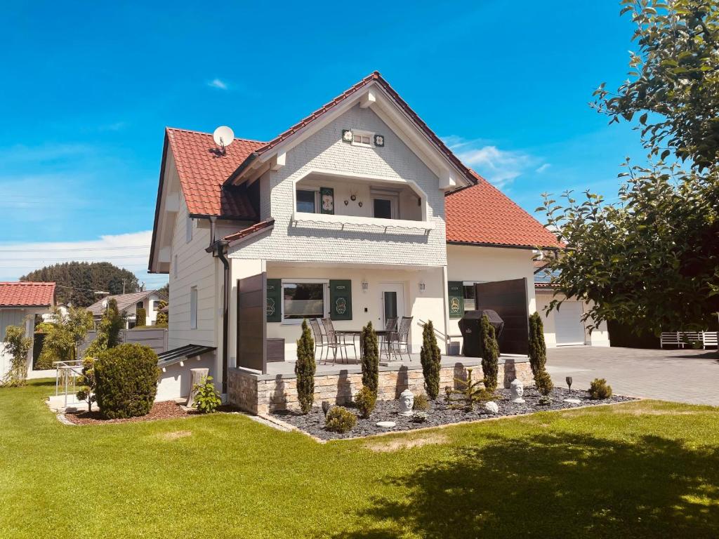 a white house with a yard with green grass at Bezauberndes Gästehaus in Zaisertshofen