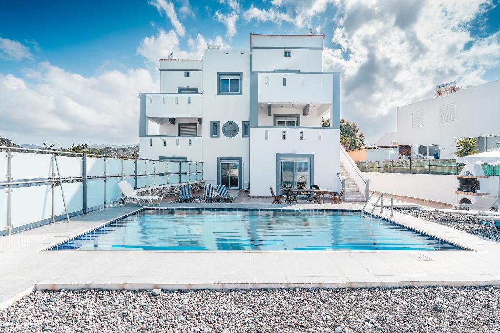 a house with a swimming pool in front of a building at Blue Pearl Apolakkia in Apolakkiá