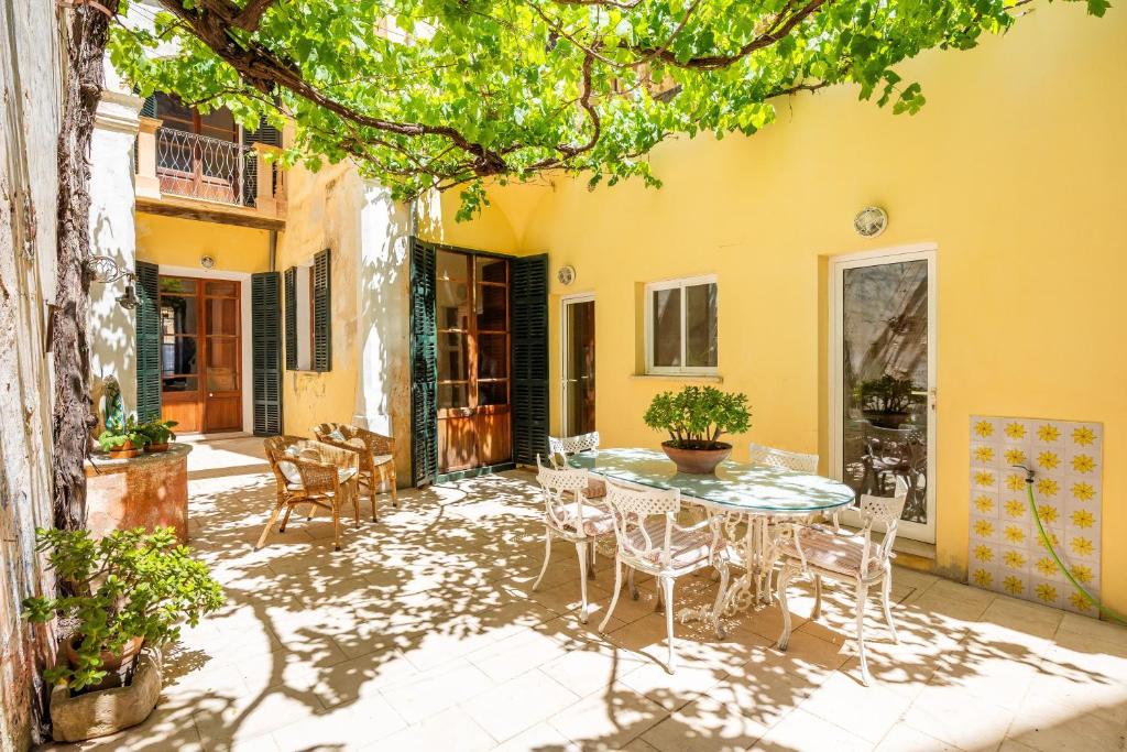 a patio with a table and chairs in front of a building at Cas Sitger in Felanitx