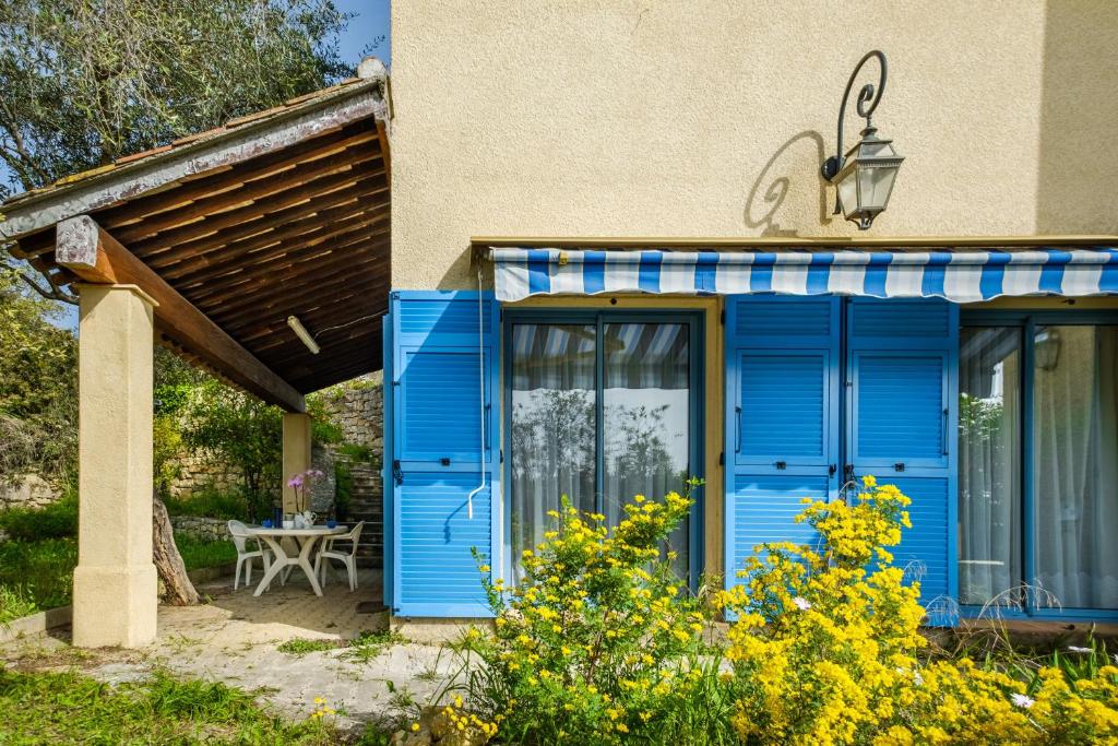 a blue front door of a house with a table at Appartement Numéro 1 - piscine in Valbonne