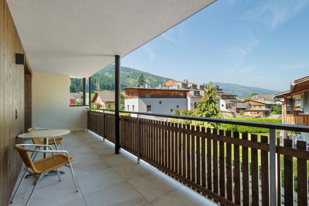 a balcony with a table and chairs and a view at Premium App Hofer Barbara in Villabassa