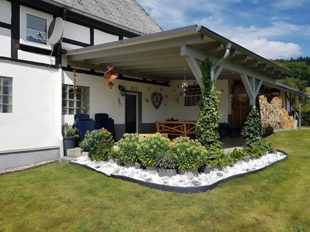 a house with a porch with plants in a yard at Ferienwohnung Lichte in Medebach
