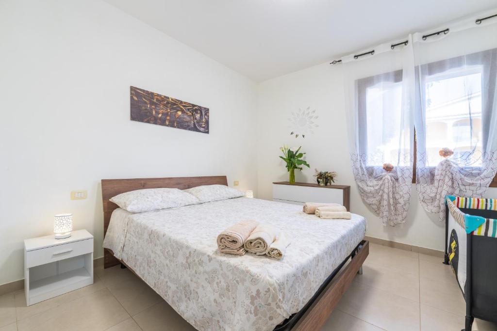 a bedroom with a bed with two towels on it at Queen's House in Pula