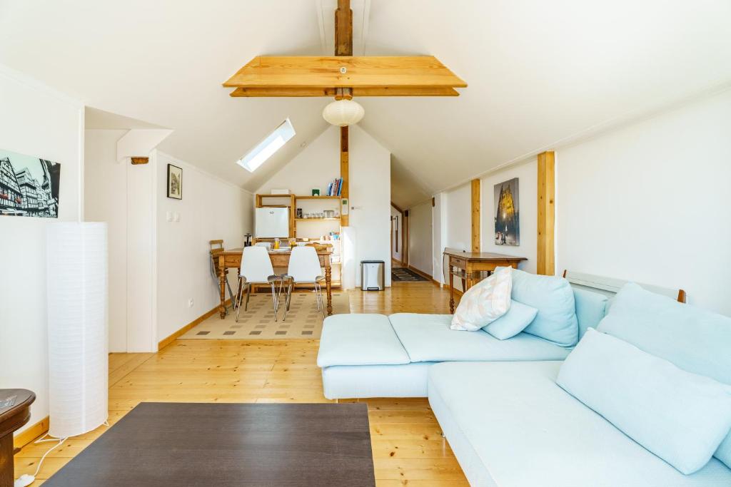 a living room with a white couch and a table at Bnb Au Petit Ruisseau in Plobsheim
