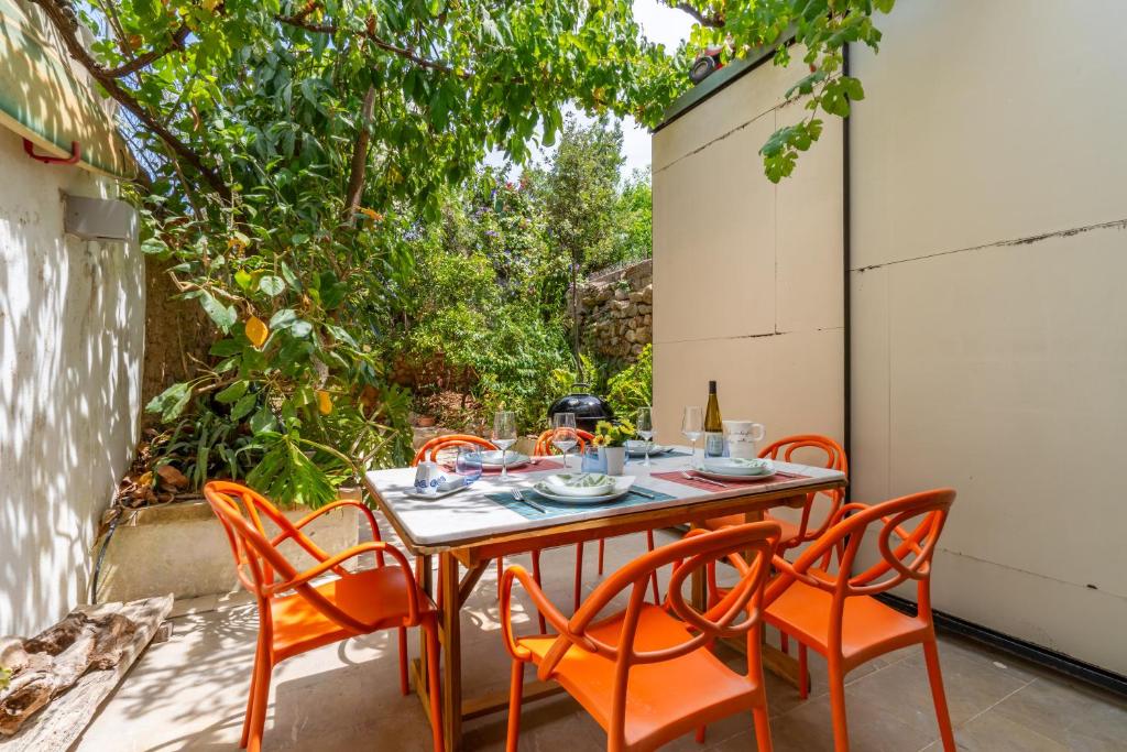 a table with orange chairs on a patio at Casa Sorteta, en el centro de Artà in Artá