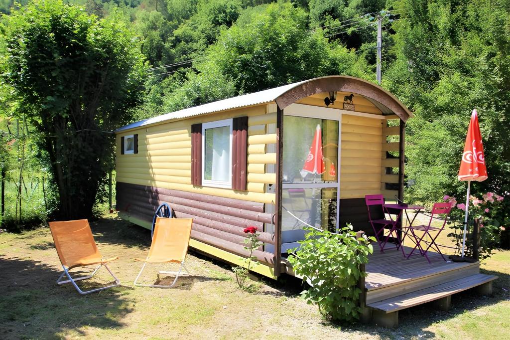 a small yellow caravan with chairs and a table at Roulotte insolite terrasse nature 1 in Touët-sur-Var