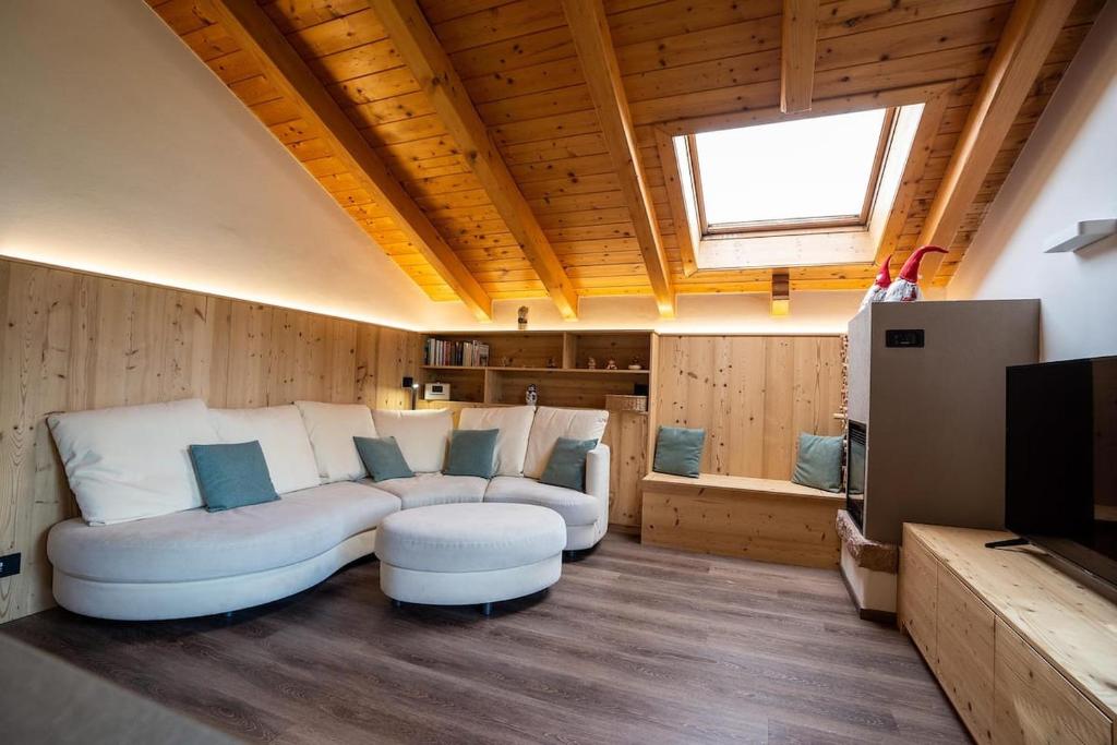 a living room with a white couch and a television at Appartamento Bucaneve in Predazzo