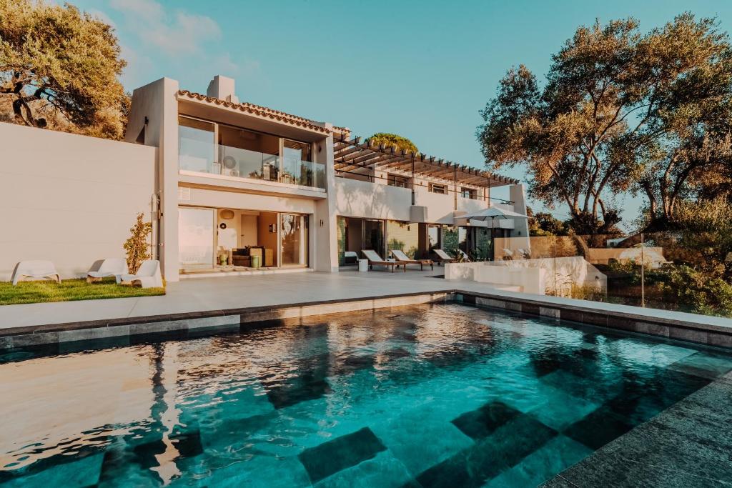 an exterior view of a house with a swimming pool at La Thébaïde in Cargèse