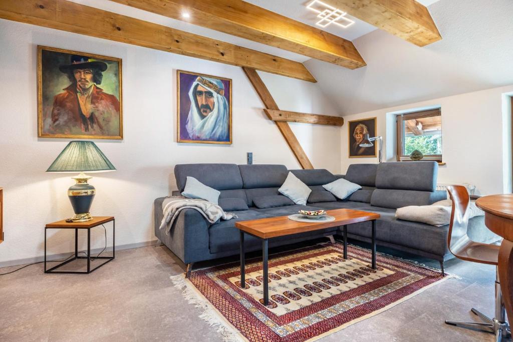 a living room with a blue couch and a table at Offene Galerie-Fewo auf 2 Etagen in Bad Gandersheim