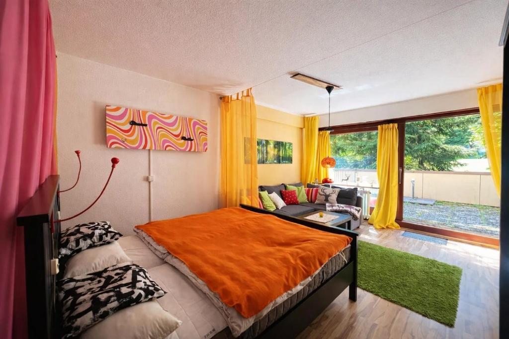 a bedroom with a bed with an orange blanket at Waldquartier in Schönwald