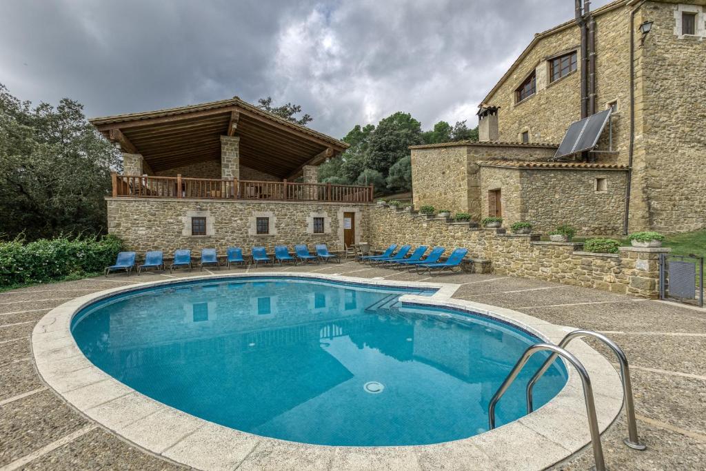 an outdoor swimming pool in front of a building at La Torre de Dalt in Santa María de Camós