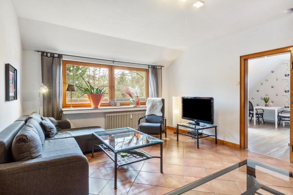 a living room with a couch and a tv at Fewo am See in Olsberg