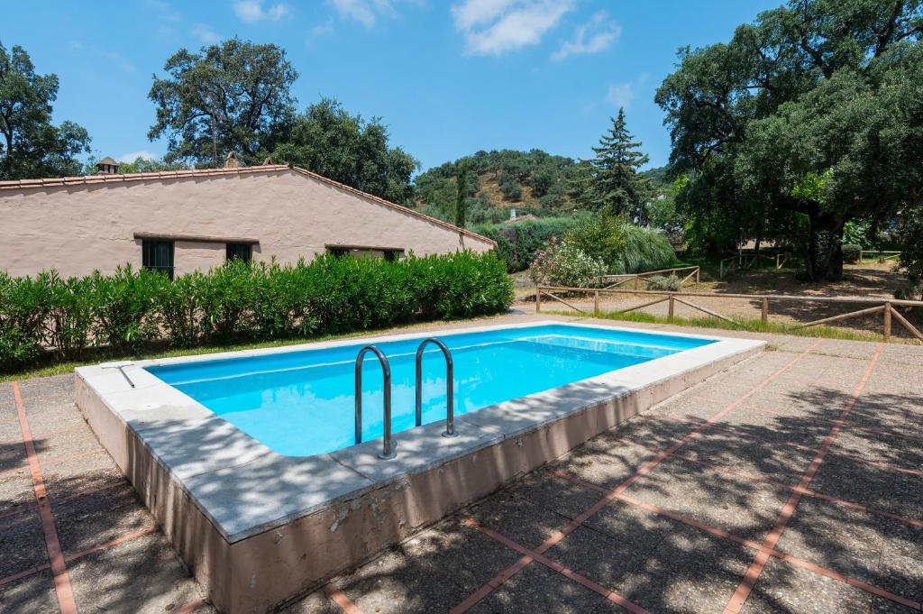 a swimming pool in front of a house at Finca Encina - piscina compartida in Alájar