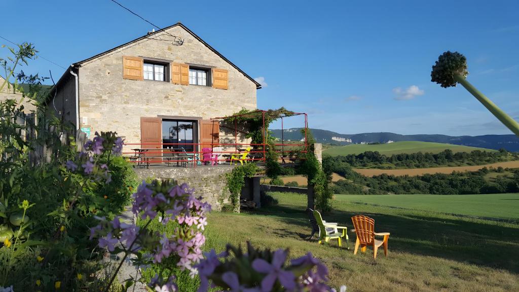 a house on a hill with chairs and flowers at Gite De Cabrières in Compeyre