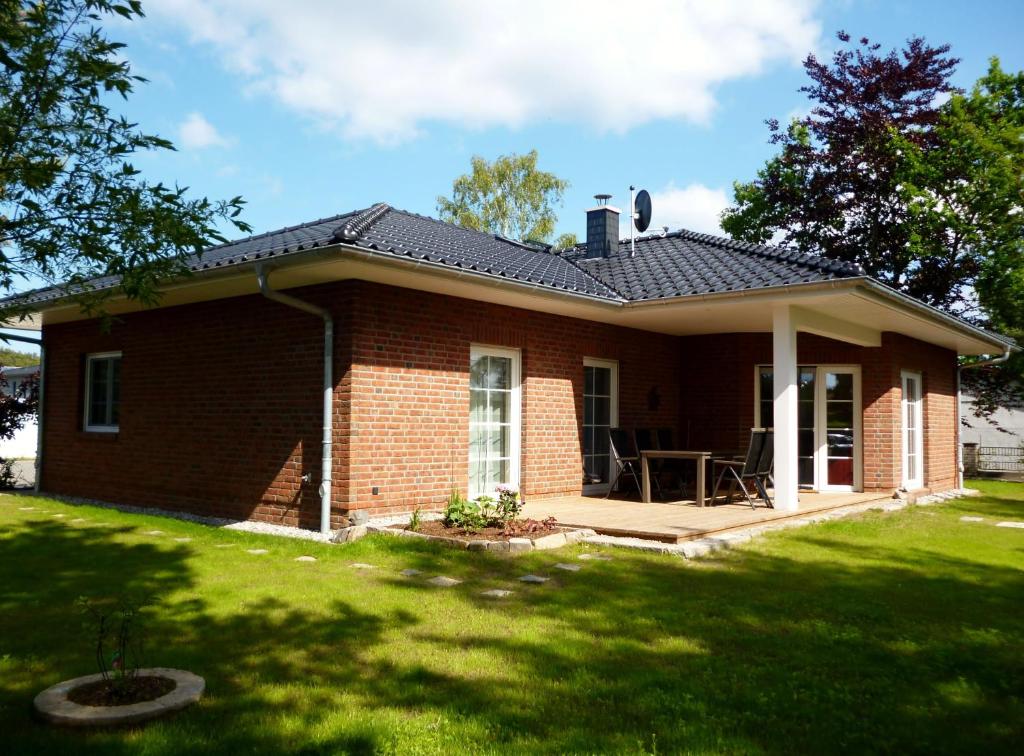a small brick house with a porch and a lawn at Ankerhaus mit Sauna und Kamin in Karlshagen