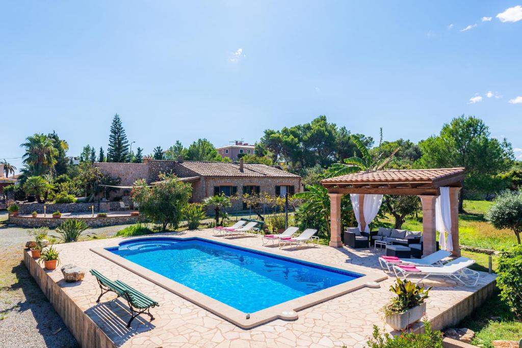 a swimming pool in a backyard with a gazebo at Finca Galardo in Son Servera