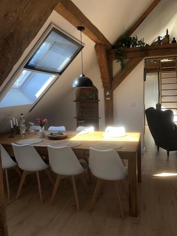 ein Esszimmer mit einem Holztisch und weißen Stühlen in der Unterkunft Lale in Wustrow