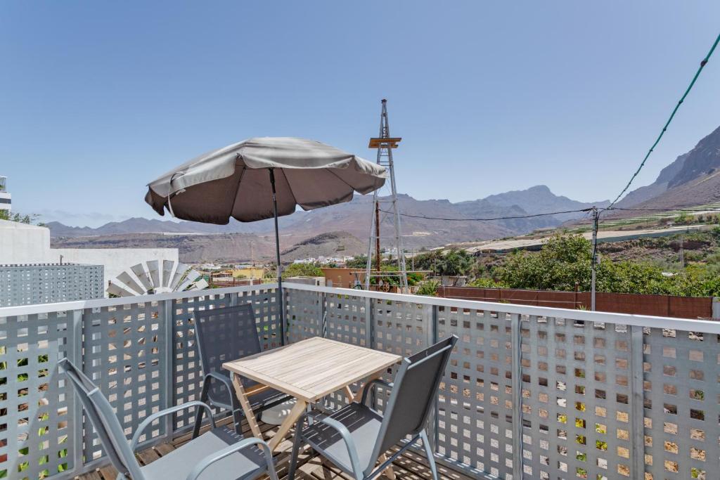 a table and chairs on a balcony with an umbrella at El Blanquizal B in San Nicolás