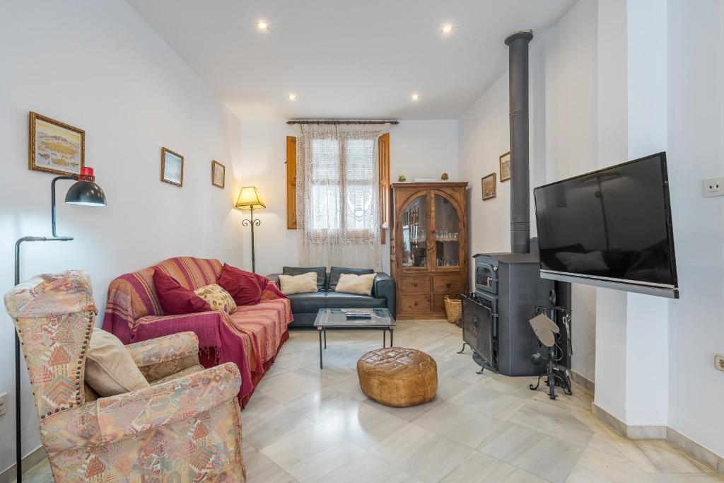 a living room with two couches and a flat screen tv at Casa El Naranjo Azul Granada in Lecrin