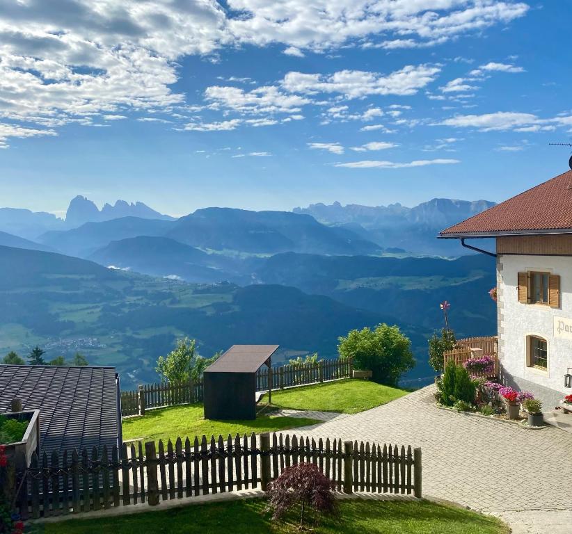a house with a fence and mountains in the background at Parndlehof in Villandro