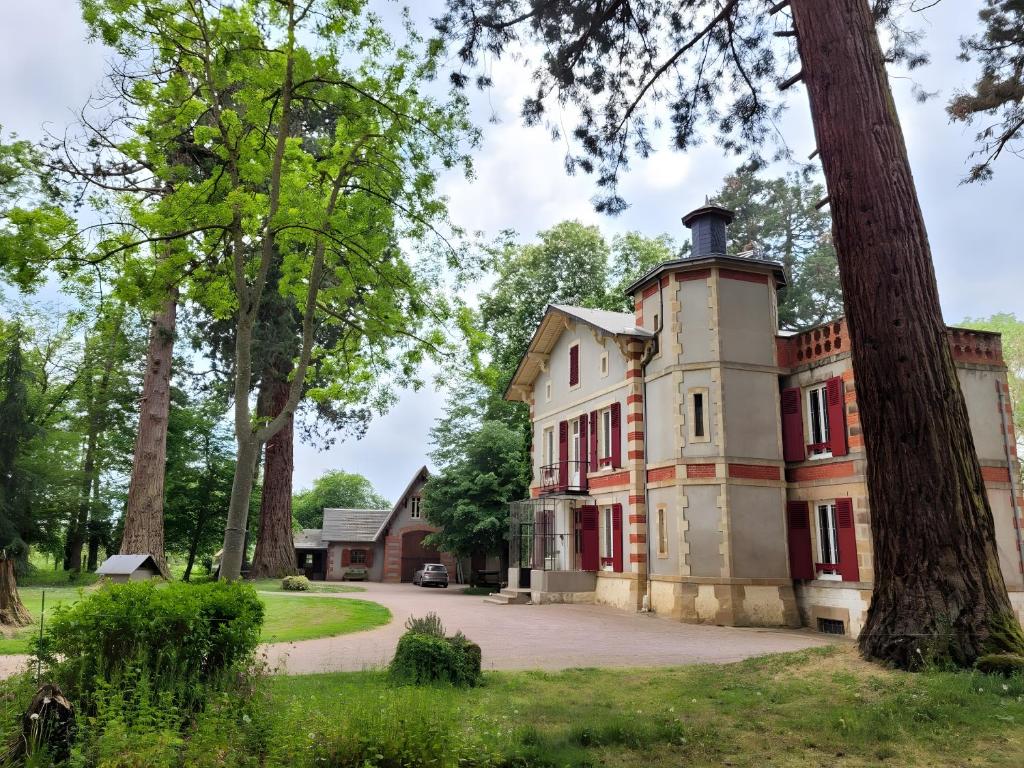 an old house with a tree in front of it at Chambre D'hôte - Le Chalêt in Ygrande