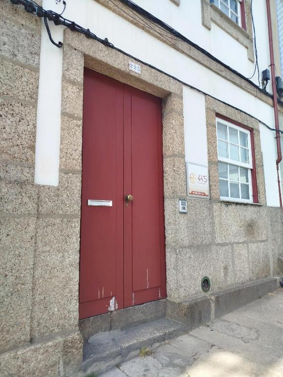 eine rote Tür an der Seite eines Gebäudes in der Unterkunft 4-As Center Apartments in Guimarães